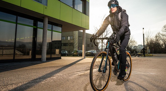 Pendler mit dem Fahrrad und schwarzer Jacke.