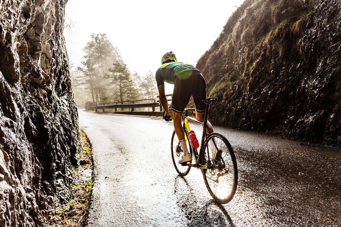 Man on road bike riding up a mountain.