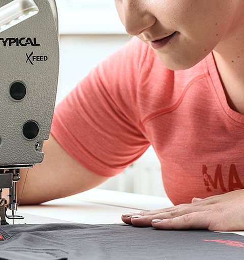 Woman sitting at sewing machine.