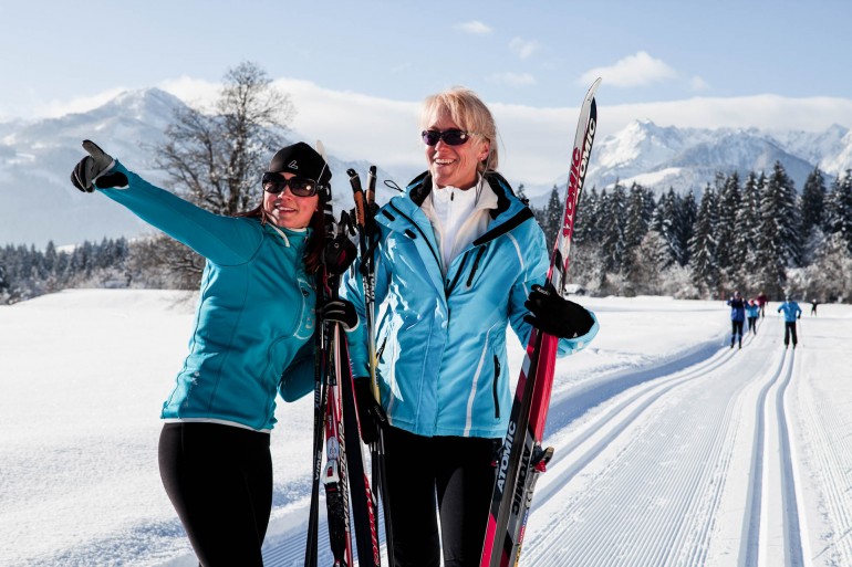 Two women with cross country equipment.