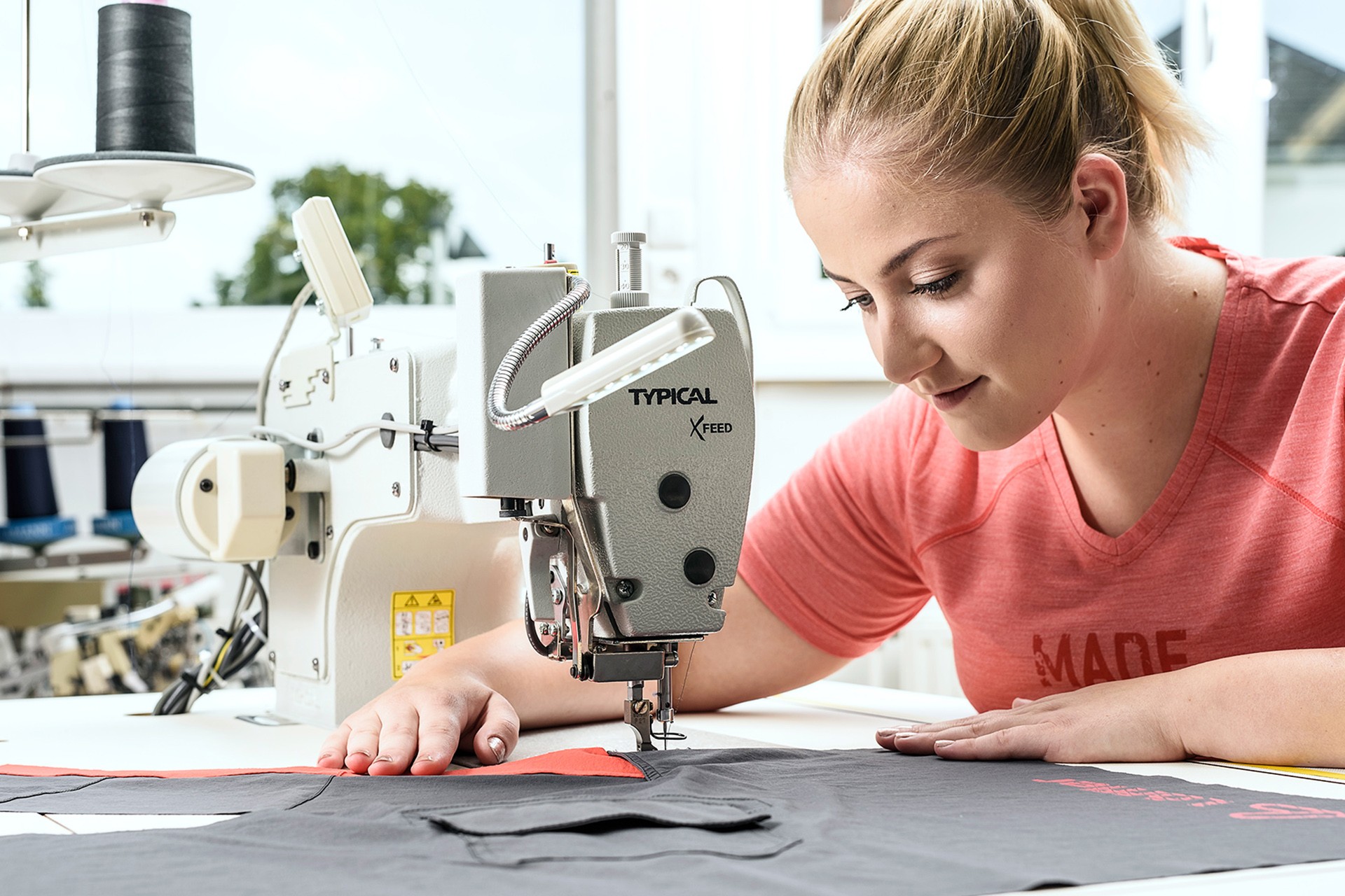 Woman sitting at sewing machine.