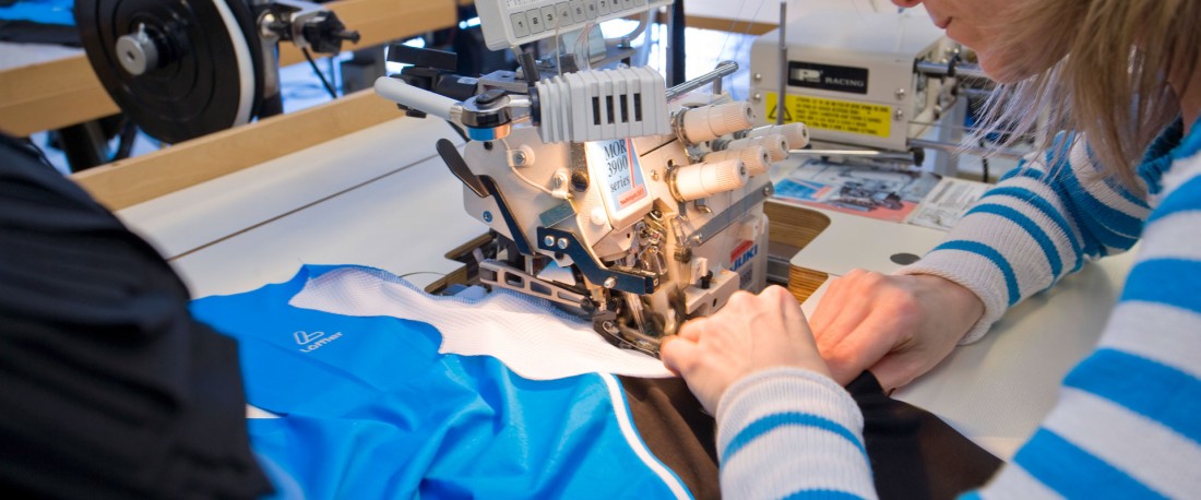 Woman working on stitching machine.