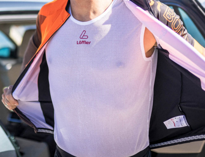 Man wearing white road bike singlet in summer.