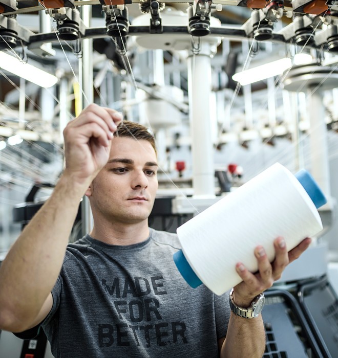 Man working on stitching machine.