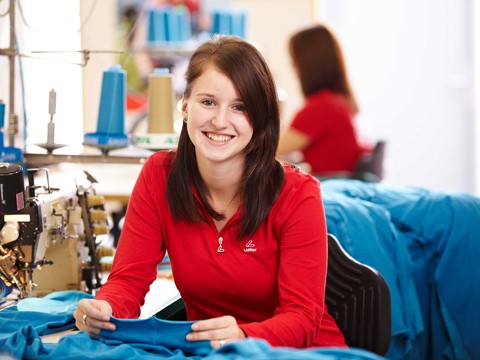 Woman sitting on sewing machine.